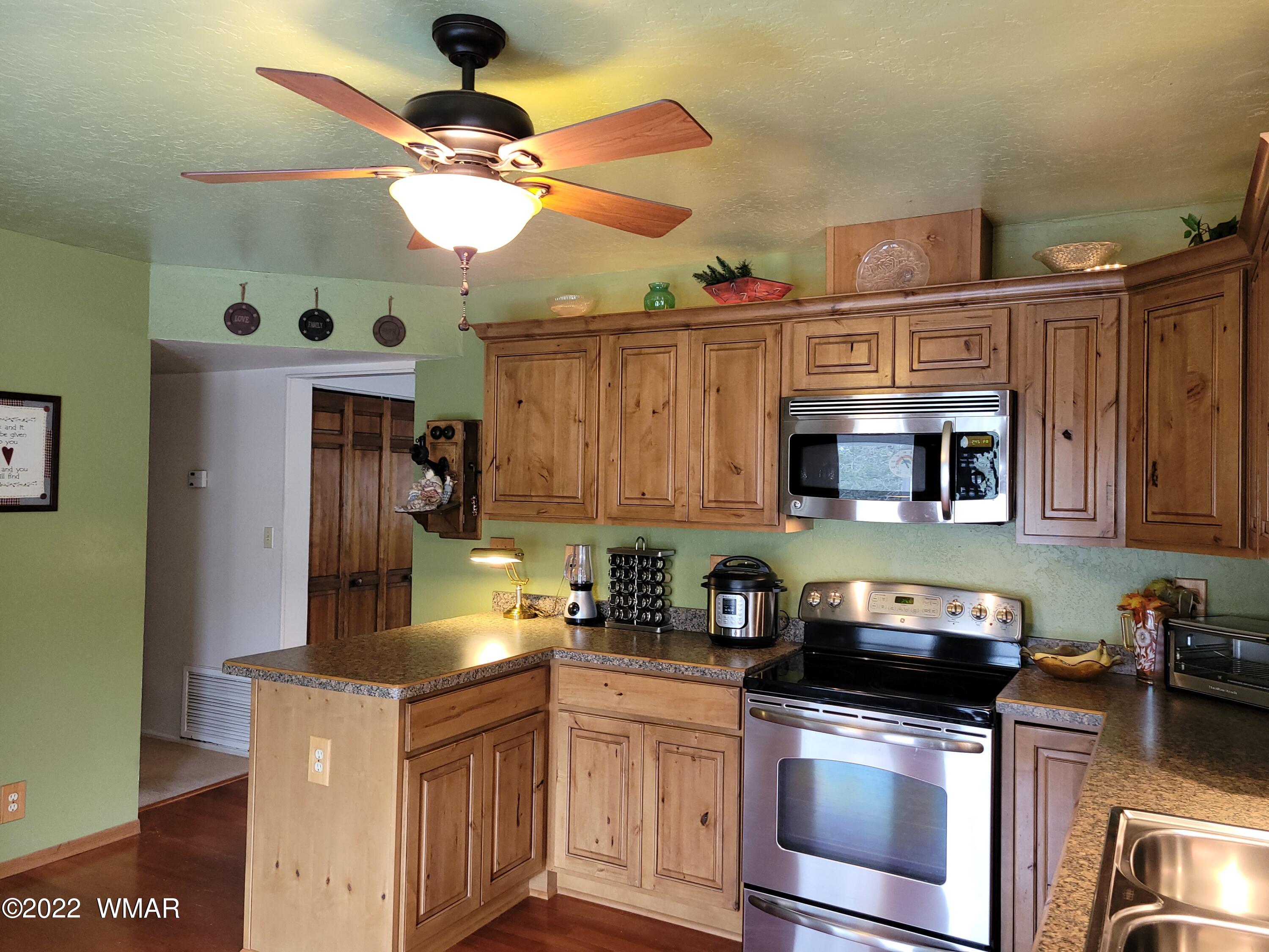 1180 Timberline Drive Eagar, AZ 85925 - Photo 15 of 48 a kitchen with stainless steel appliances granite countertop a sink a stove and refrigerator