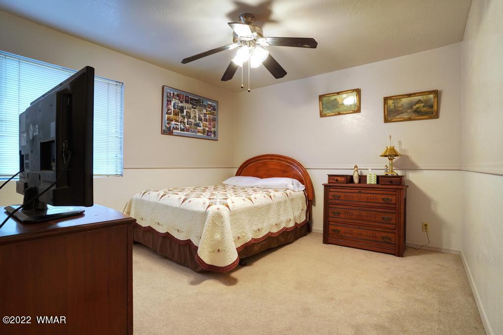 1180 Timberline Drive Eagar, AZ 85925 - Photo 22 of 48 a bedroom with a bed and a flat screen tv