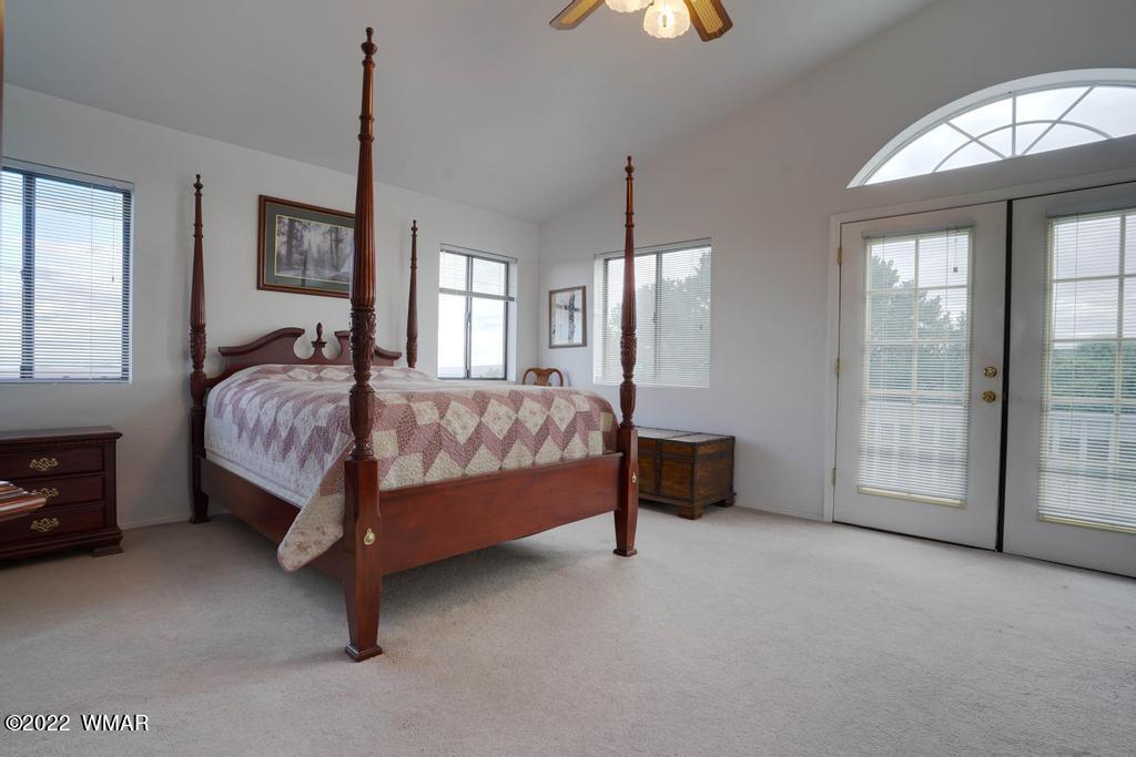 1180 Timberline Drive Eagar, AZ 85925 - Photo 26 of 48 a spacious bedroom with a bed and a chandelier