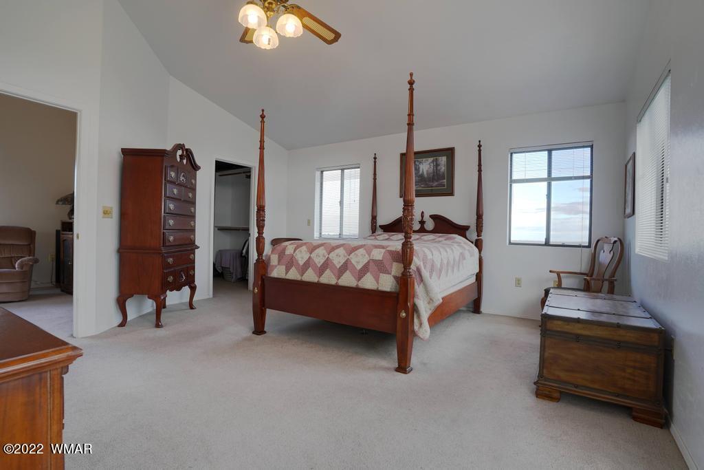 1180 Timberline Drive Eagar, AZ 85925 - Photo 27 of 48 a bedroom with a bed and a chandelier