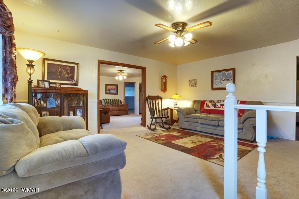 1180 Timberline Drive Eagar, AZ 85925 - Photo 4 of 48 a living room with furniture ceiling fan and a fireplace