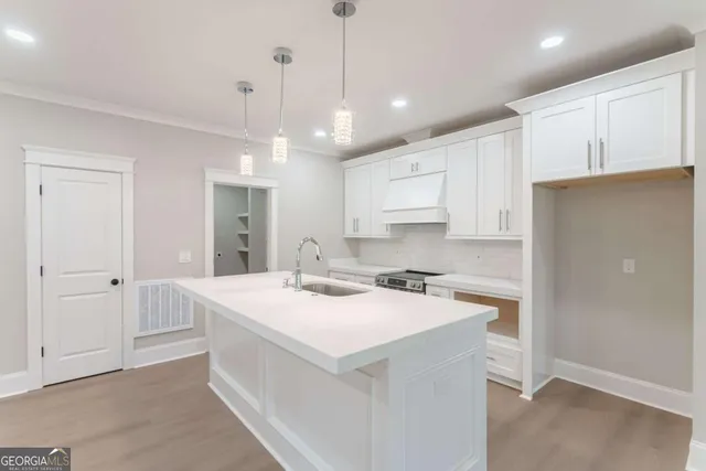 a kitchen with a sink a stove and cabinets