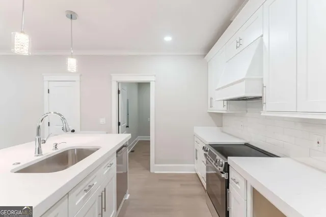 a spacious bedroom with a bed a wall painting and a potted plant