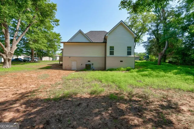 a view of a house with backyard and trees