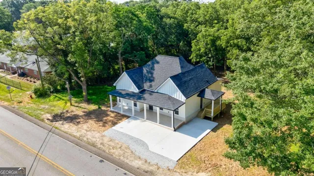a view of a house with backyard and trees