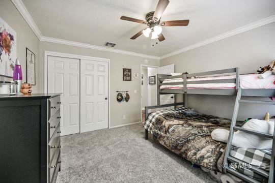 725 West Howell Avenue Ridgecrest, CA 93555 - Photo 23 of 35 a bedroom with a bed and a chandelier