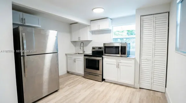 a kitchen with a refrigerator a microwave and cabinets