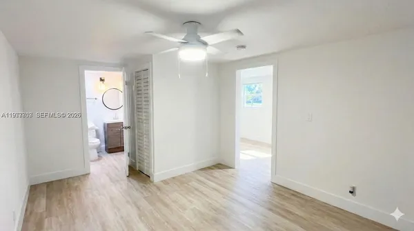 an empty room with wooden floor and mirror