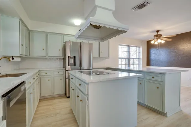 a kitchen with granite countertop a sink stove and refrigerator