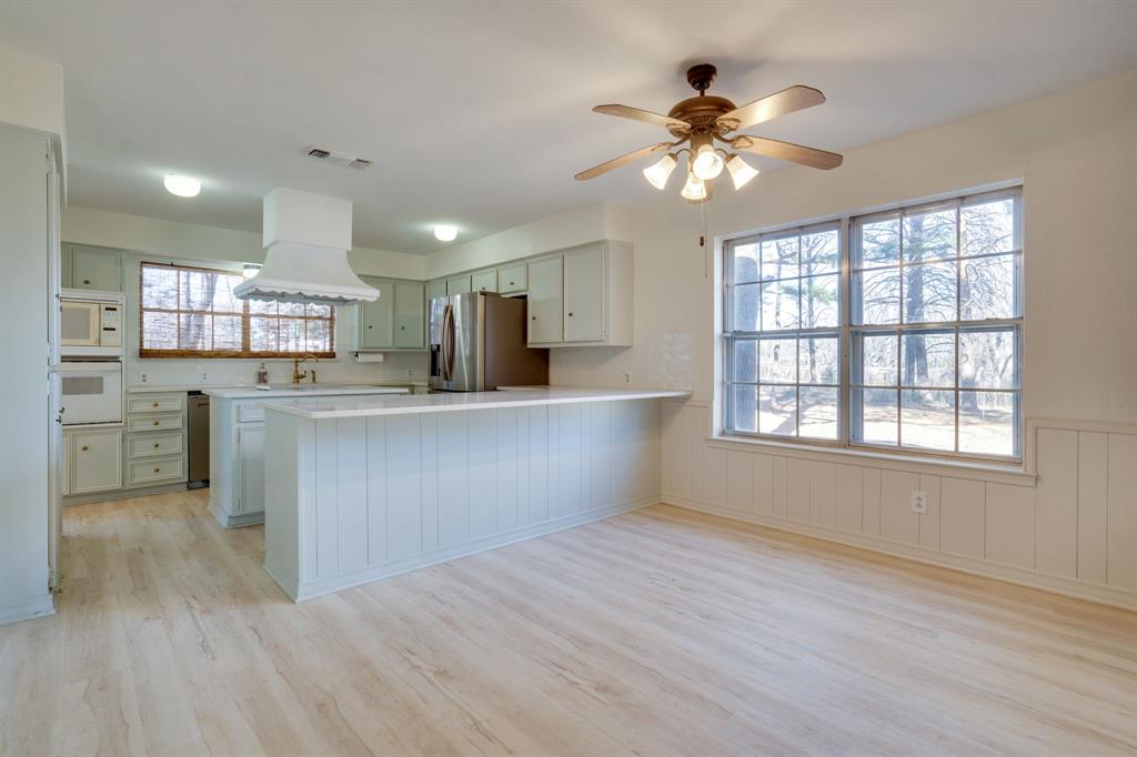 890 Copper Canyon Road Copper Canyon, TX 76226 - Photo 18 of 37 a kitchen with stainless steel appliances kitchen island wooden cabinets and a chandelier