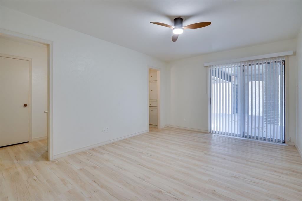 890 Copper Canyon Road Copper Canyon, TX 76226 - Photo 20 of 37 an empty room with wooden floor chandelier fan and windows