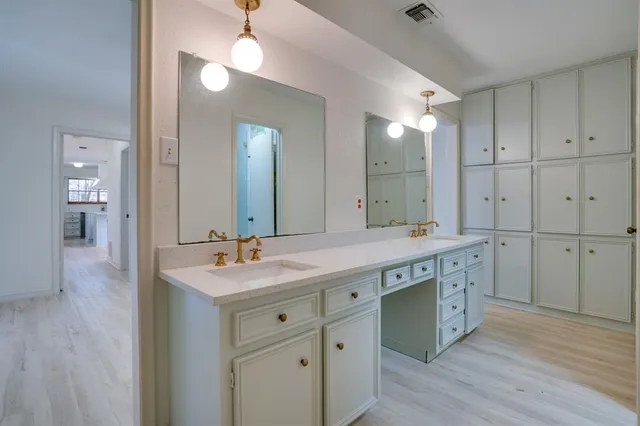 a spacious bathroom with a granite countertop sink a mirror and a shower