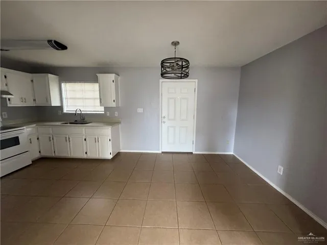 a kitchen with granite countertop a sink a stove and cabinets
