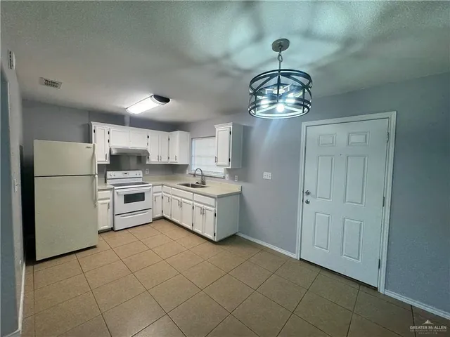 a kitchen with white cabinets and white appliances