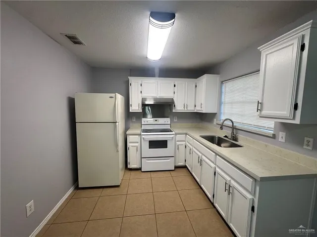 a kitchen with a white cabinets and white appliances