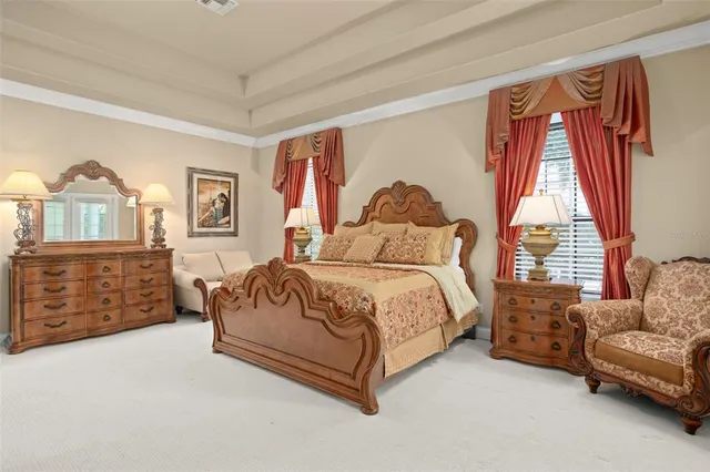 a spacious bedroom with a bed a dresser and a window