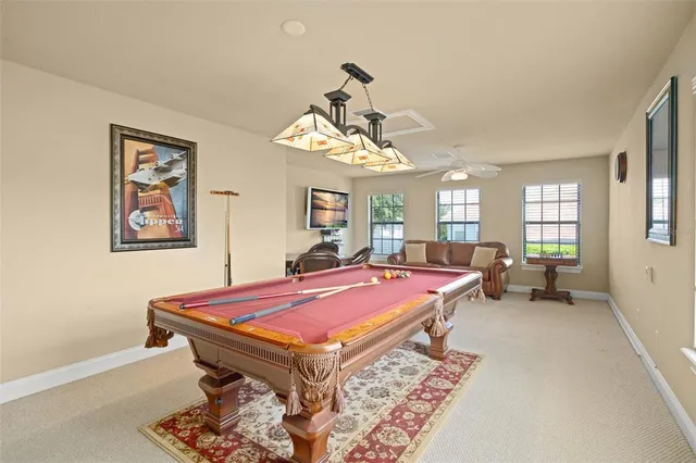 a room with pool table and windows