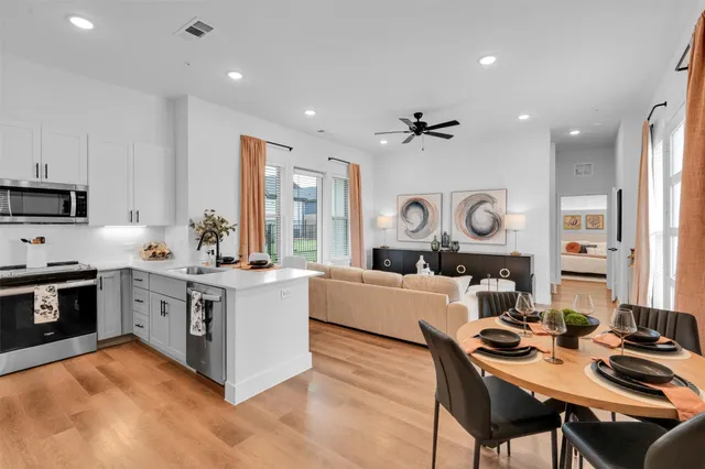 a kitchen with stainless steel appliances a stove top oven a sink and a refrigerator