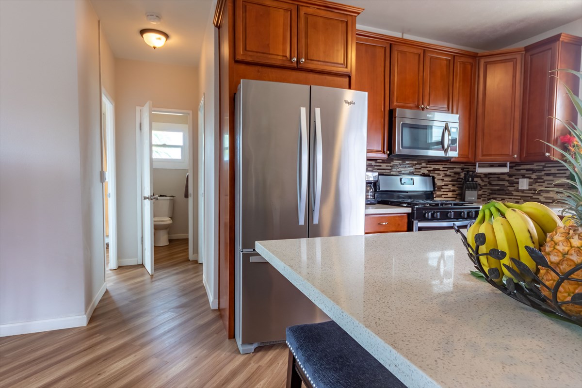 4517 Kala Road Kekaha, HI 96752 - Photo 4 of 19 a kitchen with stainless steel appliances granite countertop a refrigerator a stove and a wooden floors
