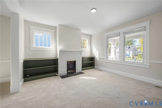 an empty room with furniture and a fireplace