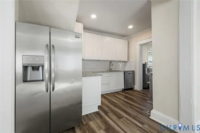 a kitchen with a refrigerator and white cabinets