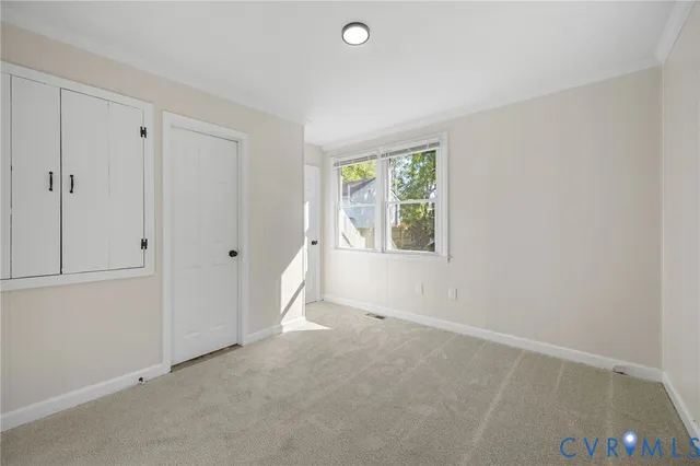 an empty room with windows and closet