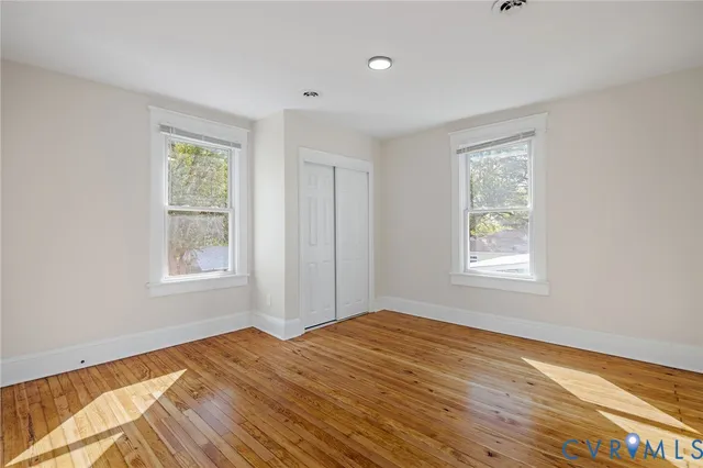 a view of empty room with wooden floor