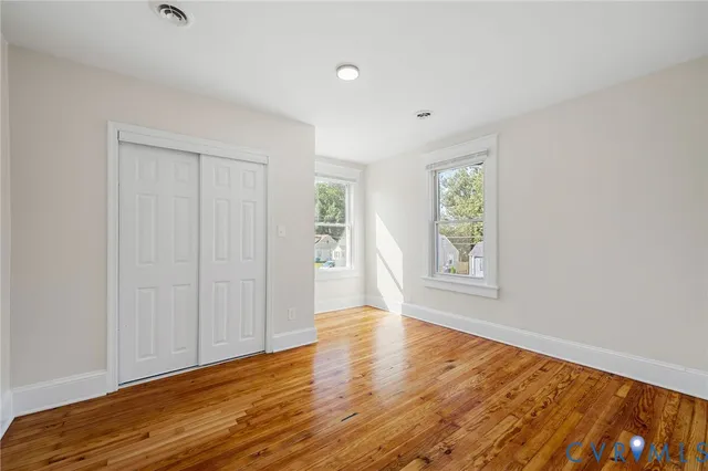 a view of empty room with wooden floor