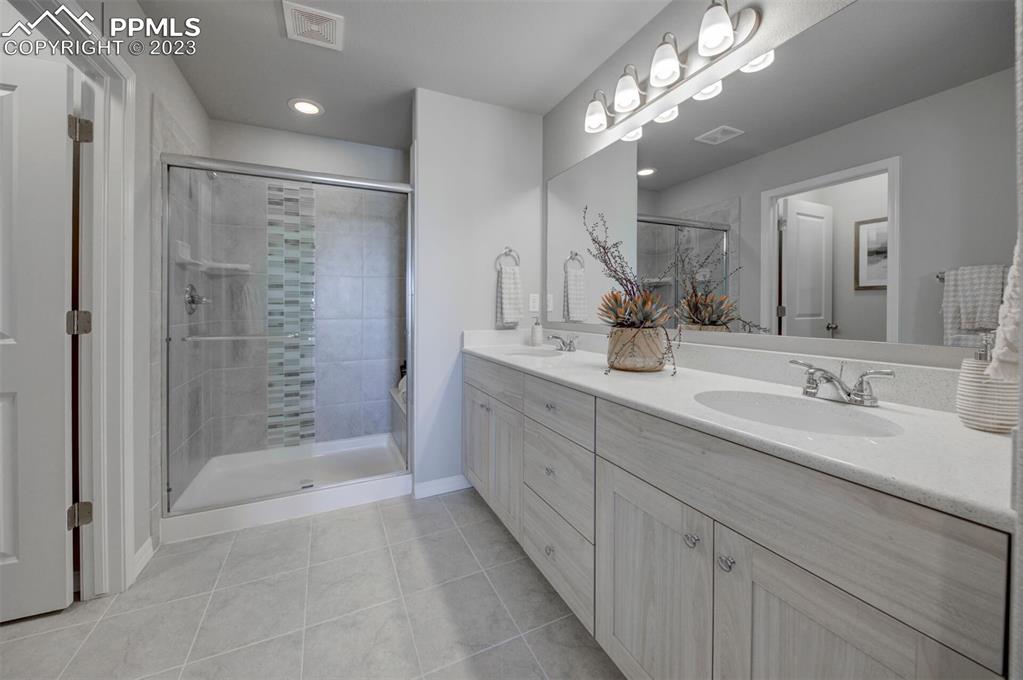 6069 Inman View Colorado Springs, CO 80924 - Photo 11 of 13 a bathroom with double sink and a mirror