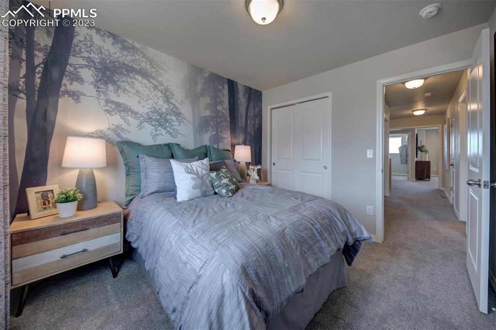 6069 Inman View Colorado Springs, CO 80924 - Photo 13 of 13 a spacious bedroom with a bed and a lamp