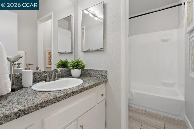 a bathroom with a granite countertop sink and a mirror