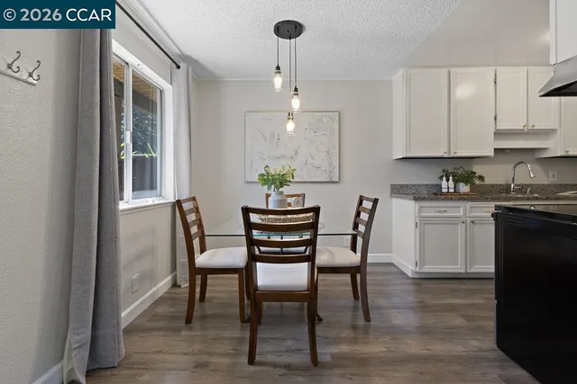 a dining room with furniture a chandelier and wooden floor