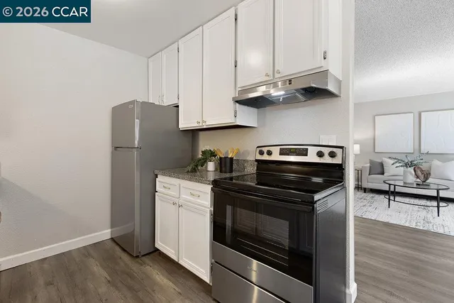 a kitchen with stainless steel appliances white cabinets and a stove top oven