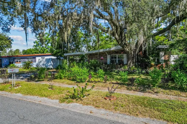 a front view of a house with a yard and potted plants
