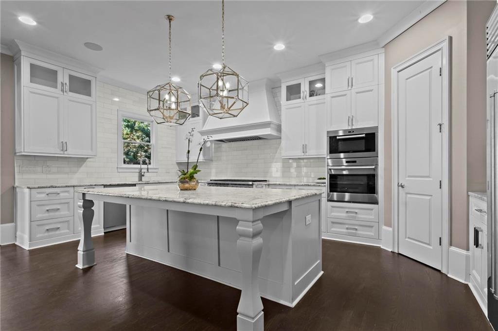 490 Belada Boulevard Atlanta, GA 30342 - Photo 13 of 42 a kitchen with kitchen island granite countertop a sink cabinets and wooden floor