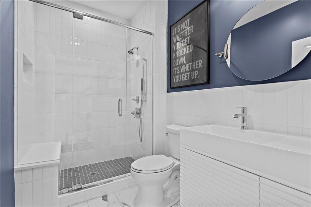 490 Belada Boulevard Atlanta, GA 30342 - Photo 24 of 42 a bathroom with a toilet sink vanity and shower