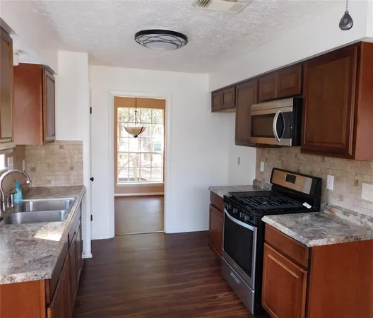 a kitchen with stainless steel appliances granite countertop a stove a sink and a microwave