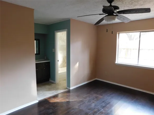an empty room with a window and a ceiling fan