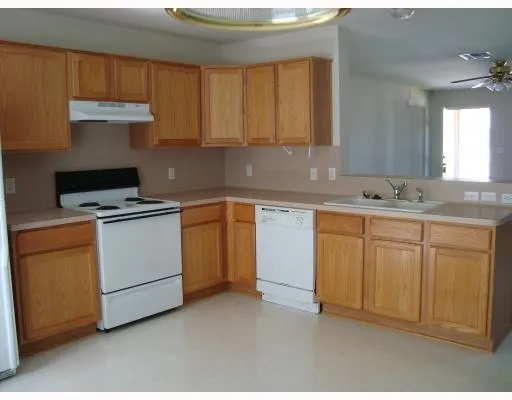 a kitchen with cabinets appliances a sink and a counter