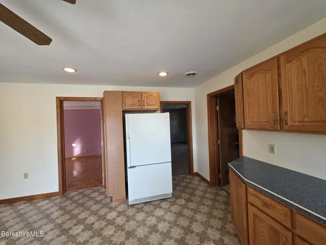 a view of kitchen with refrigerator and cabinets