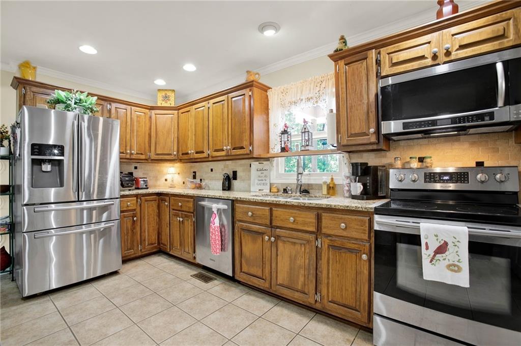 103 Mims Drive Calhoun, GA 30701 - Photo 11 of 34 a kitchen with kitchen island granite countertop stainless steel appliances and cabinets