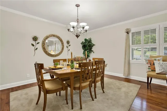 a view of a dining room with furniture a chandelier and wooden floor