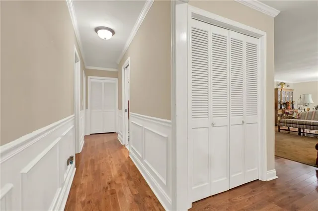 a view of a hallway with wooden floor and dining room