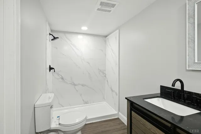 a bathroom with a sink toilet a mirror and shower