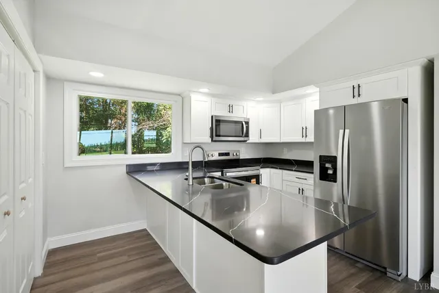 a kitchen with stainless steel appliances granite countertop a sink a stove and a refrigerator