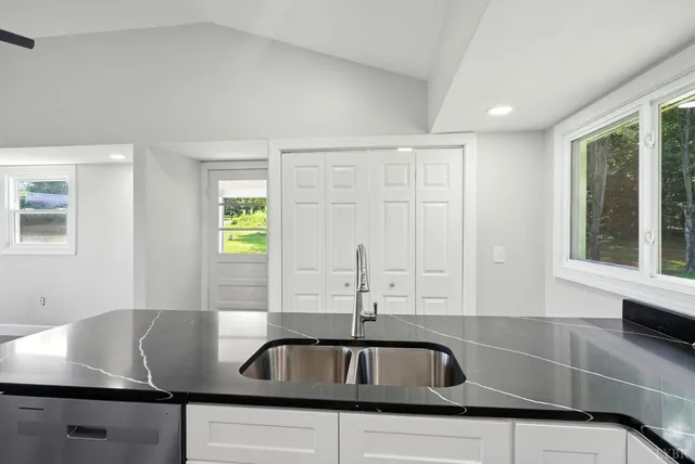 a view of a kitchen counter top a sink and cabinets