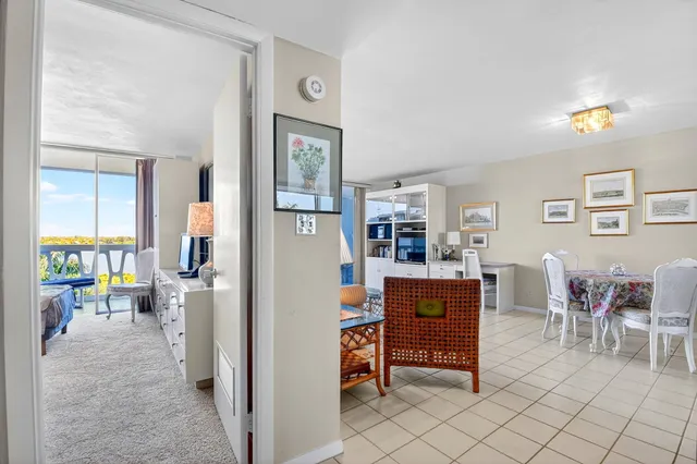 a dining room with furniture and a floor to ceiling window