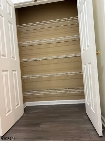 a view of a room with wooden floor and white walls