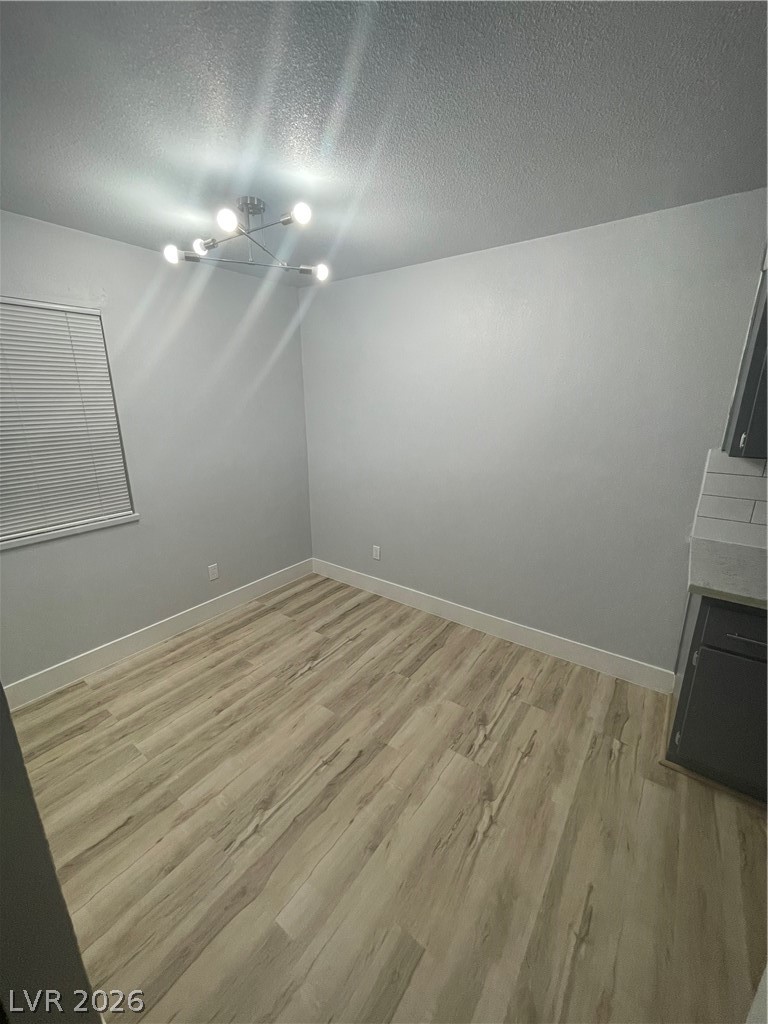 466 East Sunset Road, Unit D Henderson, NV 89011 - Photo 5 of 20 Additional living space with a textured ceiling and light wood-type flooring