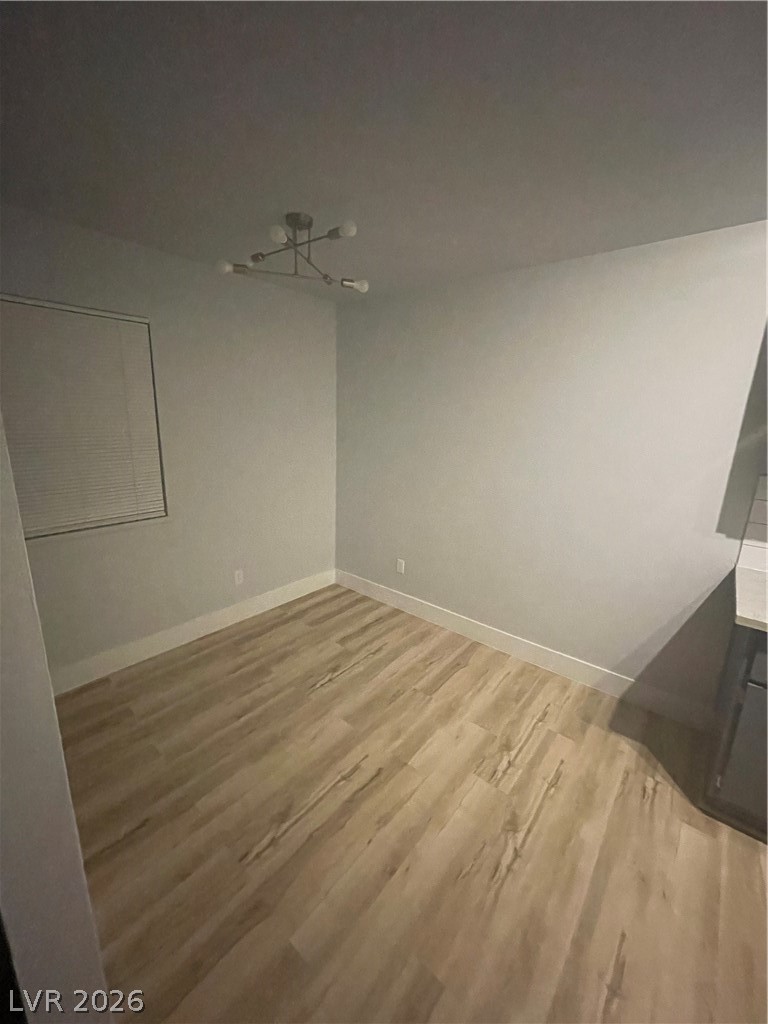 466 East Sunset Road, Unit D Henderson, NV 89011 - Photo 6 of 20 Unfurnished dining area featuring baseboards and light wood-style flooring